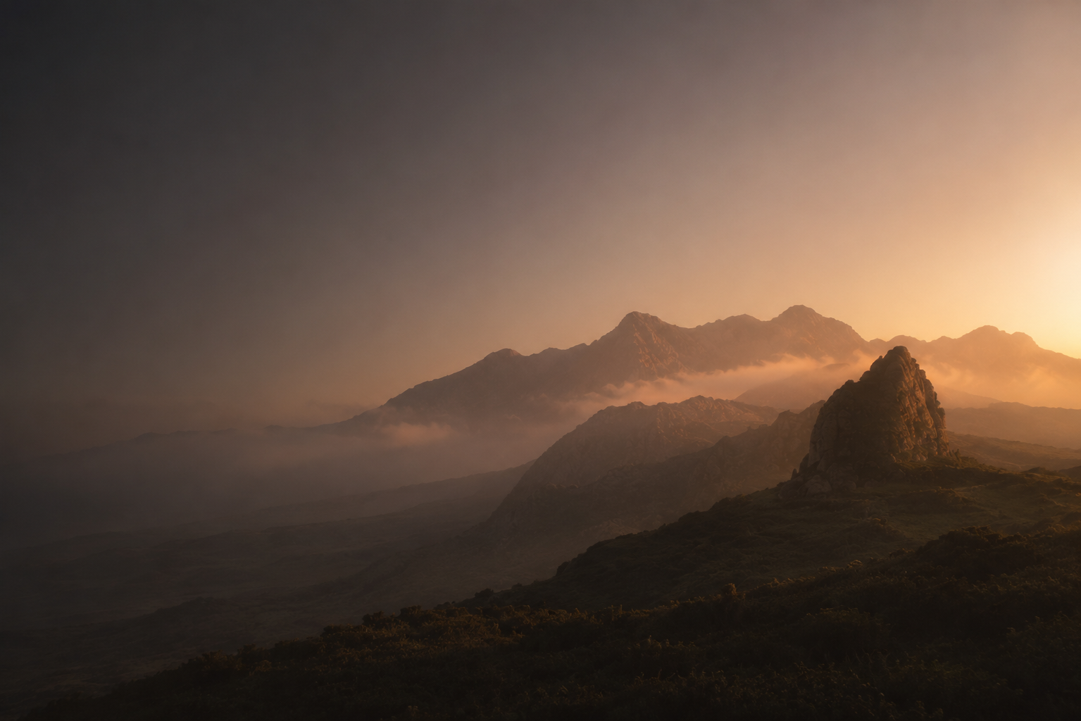 Mistige bergtoppen bij zonsopkomst